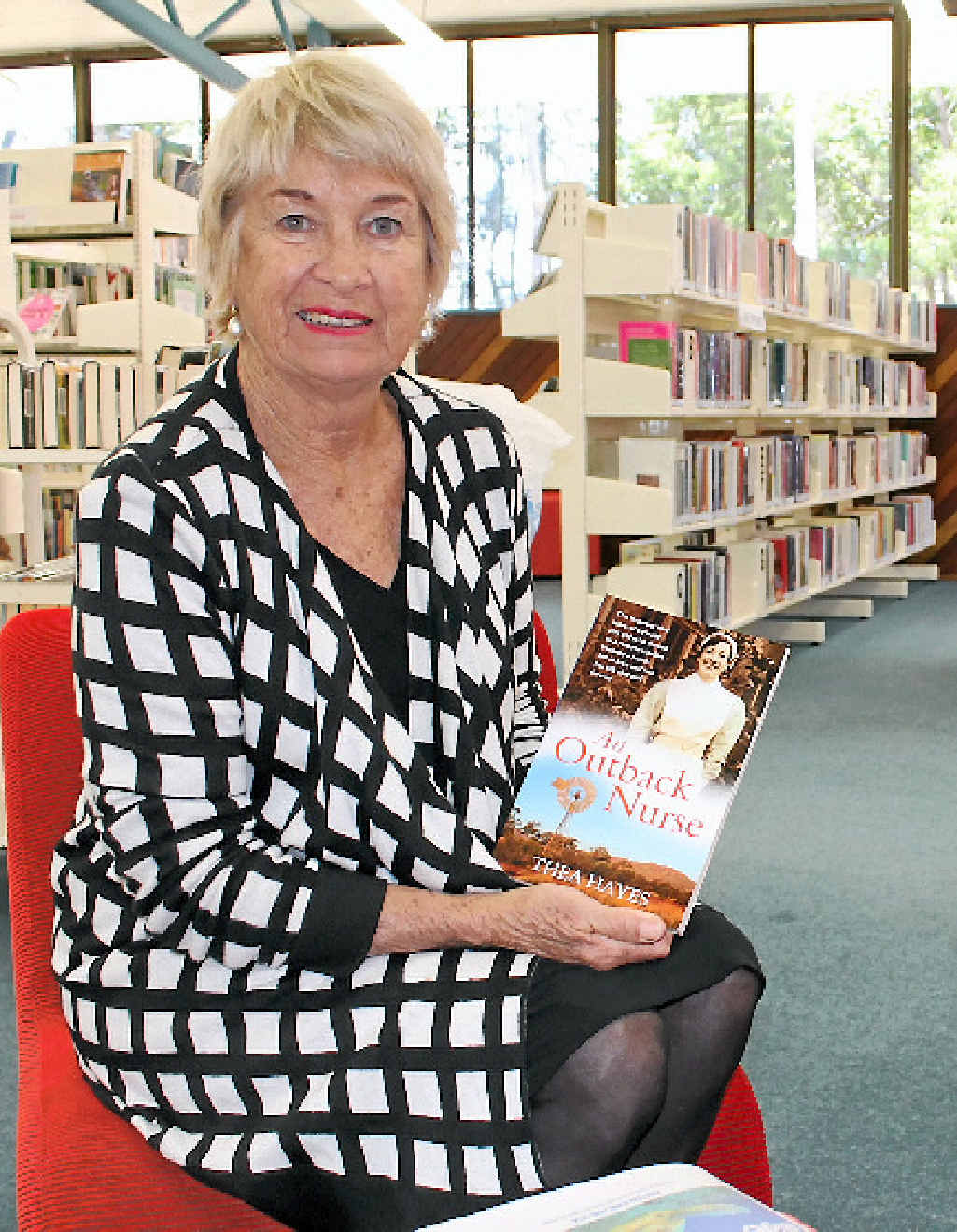 TOP TALK: Travelling author Thea Hayes with her book An Outback Nurse.